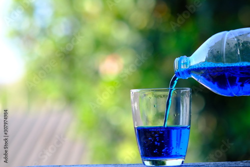 pouring fresh blue water into glass