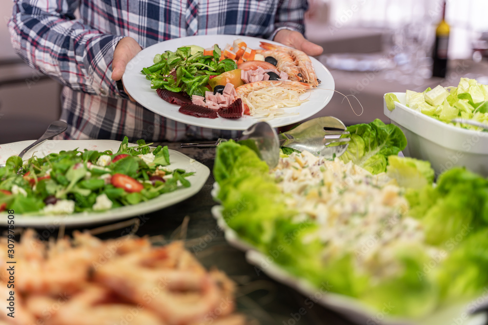 Hands of a girl showing a plate of salad with prawns in a self-service restaurant Hands of a girl showing a plate of salad with prawns in a self-service restaurant