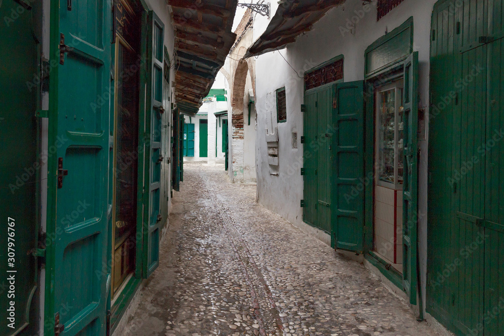 Green wooden doors of the old stores in Tetouan Medina quarter in Northern Morocco. A medina is typically walled, with many narrow and maze-like streets.