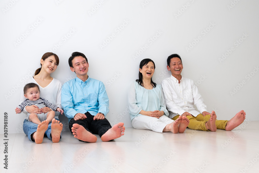 子供を抱っこして座っている3世代家族