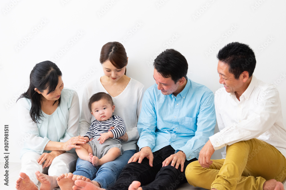  子供を抱っこして座っている3世代家族