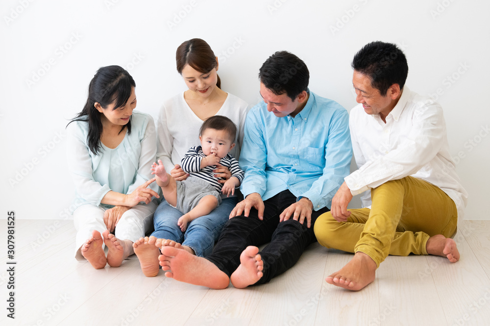  子供を抱っこして座っている3世代家族