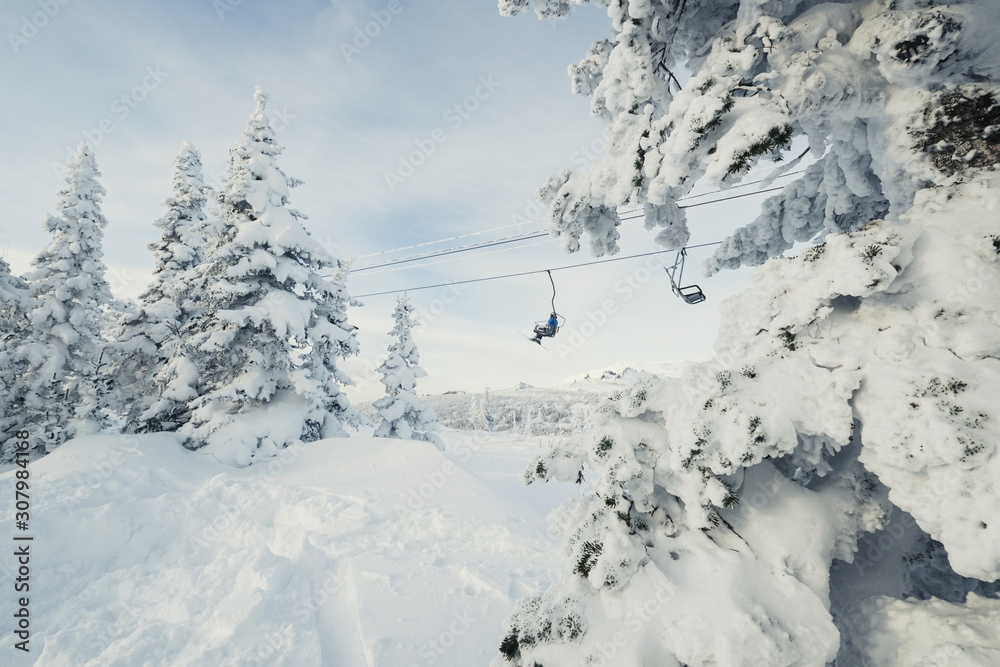 ski lift behind Frozen snow cowered trees, mountains landscape in ski resort