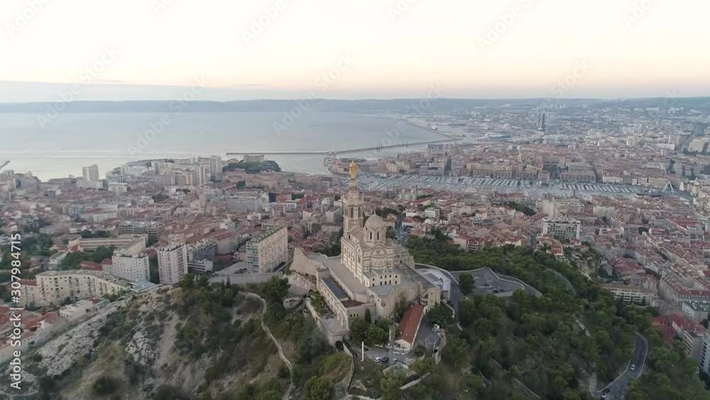 the beautiful city of marseille seen from the drone. The notre dame cathedral is located on the top of the hill, surrounded by buildings the beautiful city of marseille seen from the drone. The notre dame cathedral is located on the top of the hill, surrounded by buildings