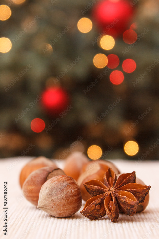 Hazelnut, anise and christmas tree with lights in background Hazelnut, anise and christmas tree with lights in background