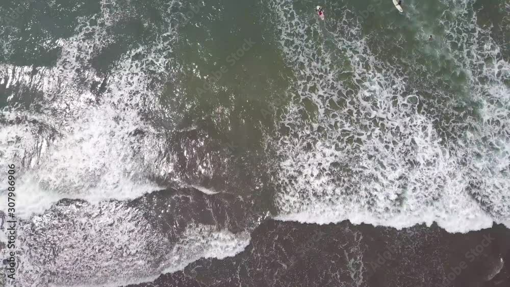 Aerial shot looking straight down at surfers in waves. Aerial shot looking straight down at surfers in waves.
