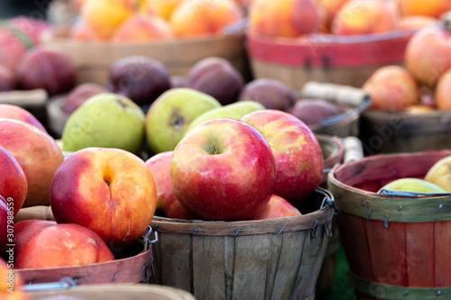 Batches of apples in wooden baskets for sale at a local farmers market