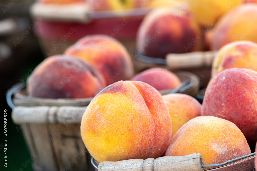 Close up image of wooden baskets of peaches at a farmers market Close up image of wooden baskets of peaches at a farmers market