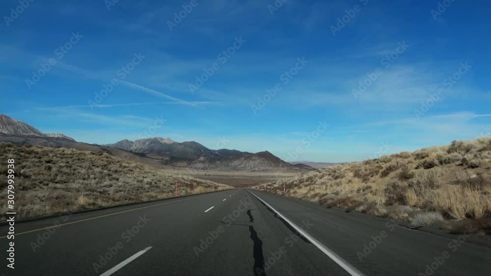Driving Down Center Of Desert Road, colorful blue sky Driving Down Center Of Desert Road, colorful blue sky