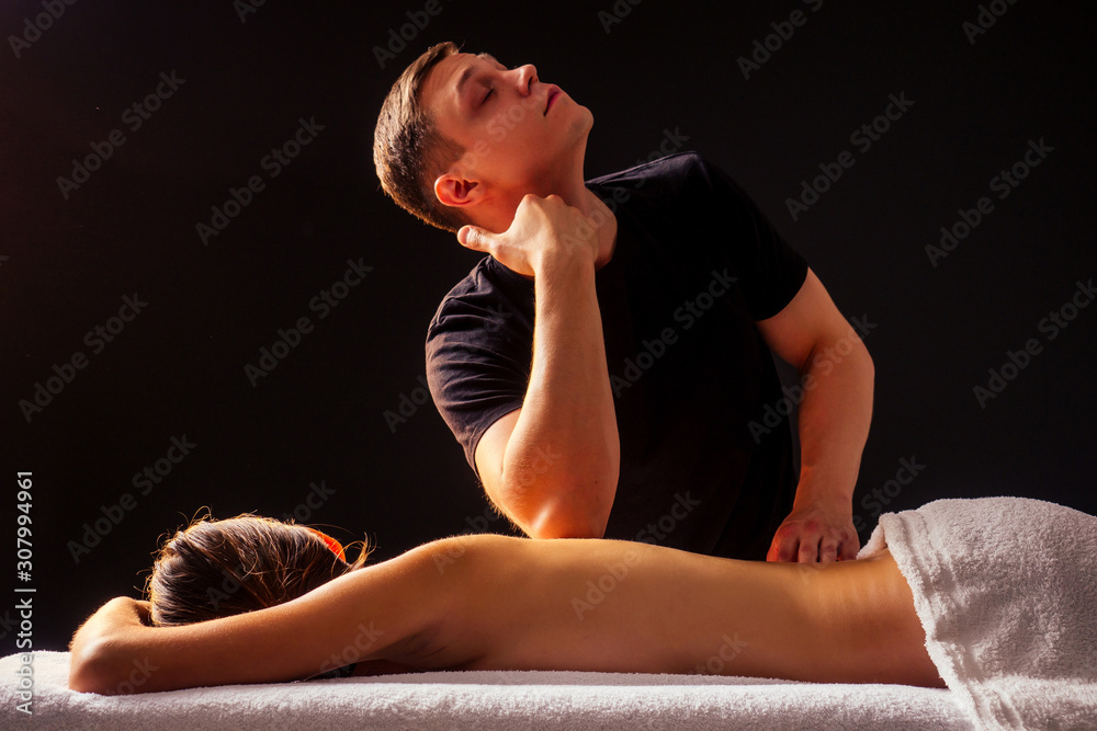 Obraz premium close-up masseur hands doing back massage to female client in spa center