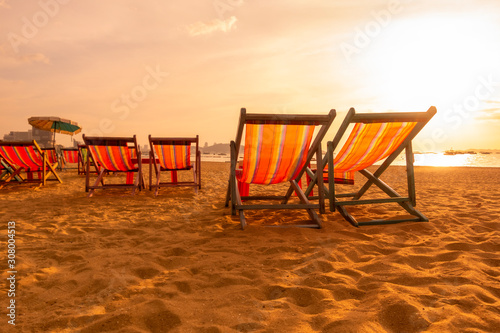 A group of red canvas beds on the beach with sunset atmospher