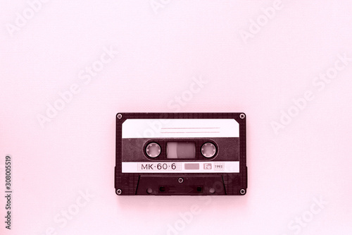 Old audio tape cassette close-up. Old technology concept. Pink color toned