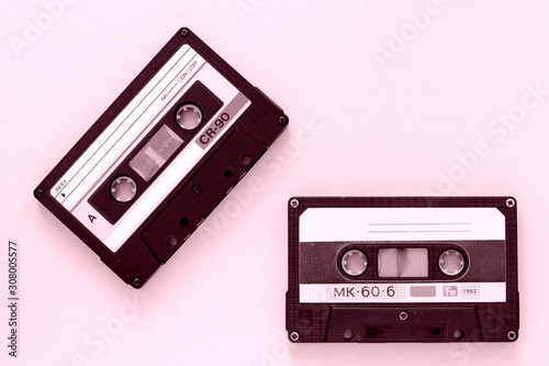 Two old audio tape cassettes close-up. Old technology concept. Pink color toned