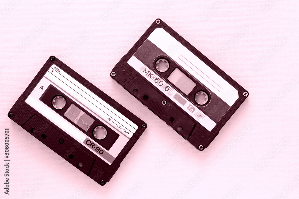Two old audio tape cassettes close-up. Old technology concept. Pink color toned