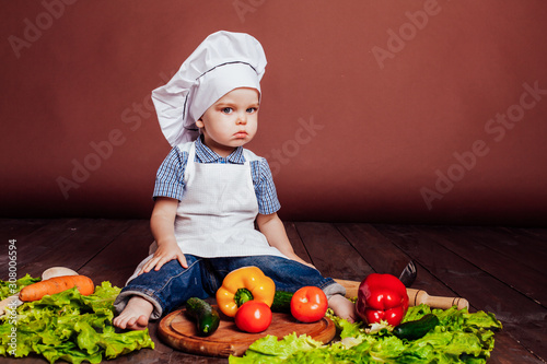 little boy Cook carrots, peppers, tomatoes, lettuce, photo