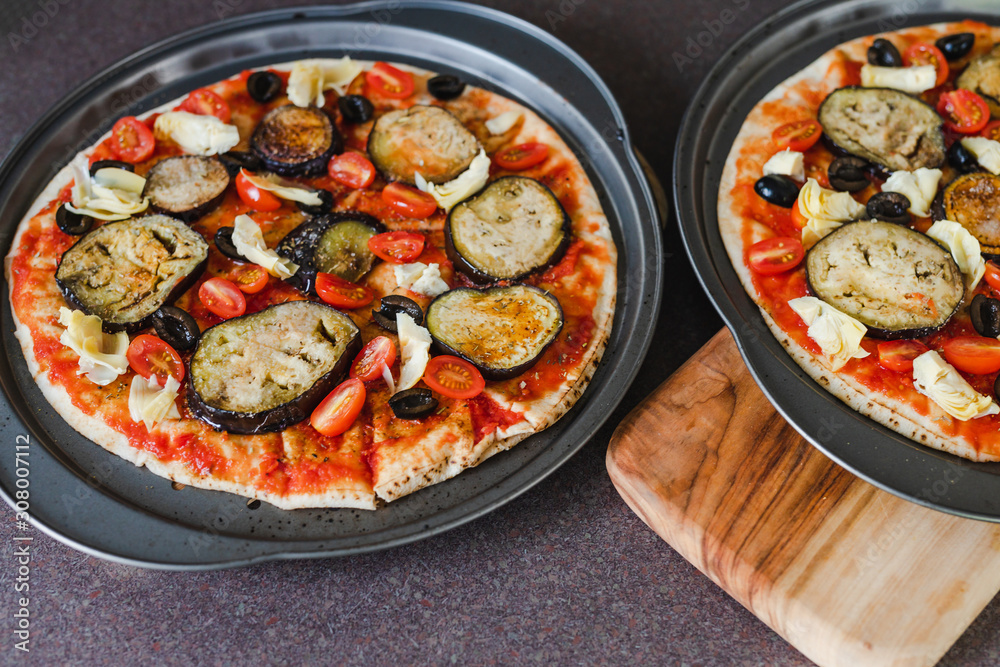 pizza base with tomato sauce veggies and aubergine before going in the oven pizza base with tomato sauce veggies and aubergine before going in the oven