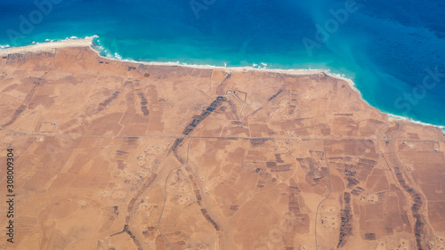 Earth's line. A perspective of the ground's colors and shapes. Aerial view of the Egyptian coast overlooking the Mediterranean sea. View from the airplane window. Sea with fantastic turquoise colors