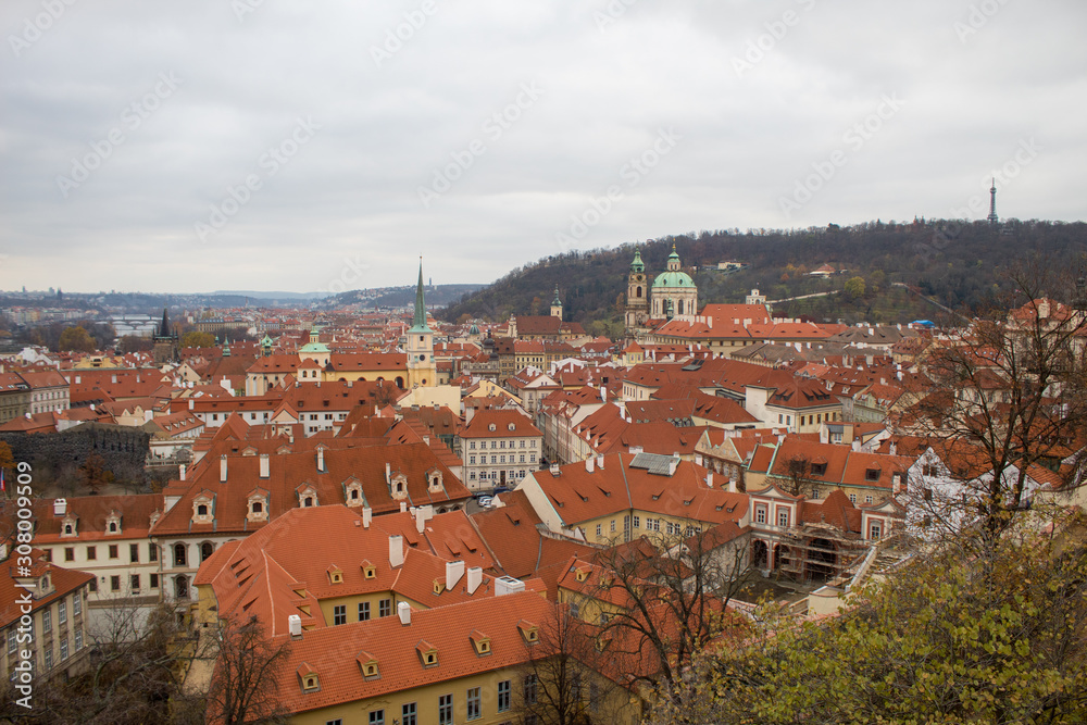 Panorama of the Czech city of Prague with tiled orange roofs from the observation deck of Prague Castle on a cloudy day on the eve of Christmas.
