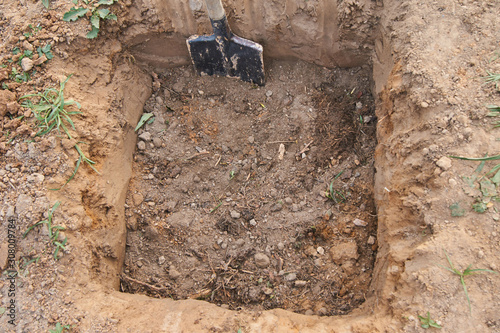 The gardener makes a hole in the ground for planting trees