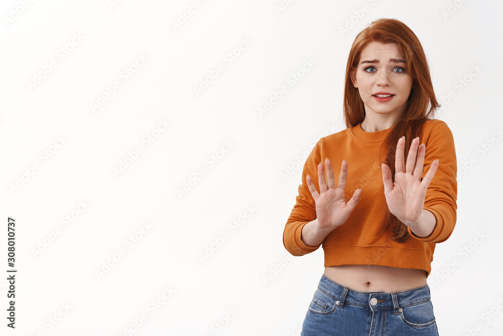 Awkward and unimpressed cute redhead female model in orange cropped top, raising hands defensive in stop, please no gesture, smiling thanking for offer but rejecting, give refusal, white background Awkward and unimpressed cute redhead female model in orange cropped top, raising hands defensive in stop, please no gesture, smiling thanking for offer but rejecting, give refusal, white background