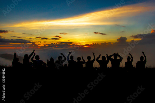 People or traveler sit at cliff and see sunset over the clouds and mountain of forest in silhouette tone at Doi MonJong of Chiangmai, Thailand, Asia.