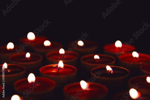 Burning red candles on a dark background.