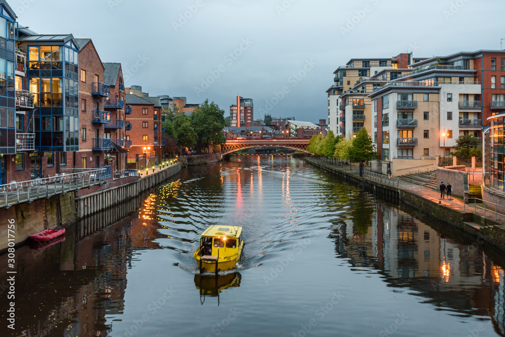 The River Aire in the centre of Leeds, West Yorkshire, England, UK, with apartment buildings on either side, some converted ware