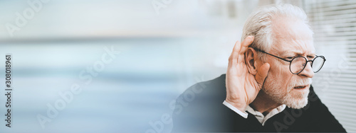 Senior man with hearing problems; panoramic banner