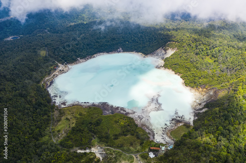 View from above, stunning aerial view of the Talaga Bodas Lake surrounded by a green tropical forest. Talaga Bodas crater is one of the tourist attractions in the Garut Regency in Java, Indonesia. photo