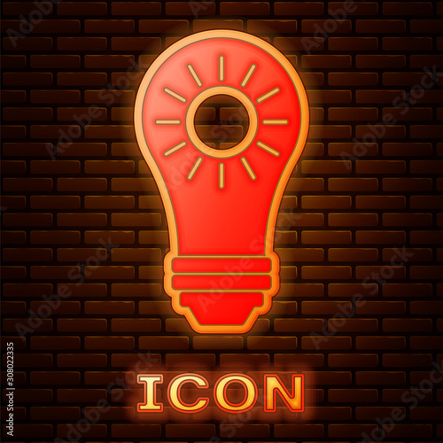 Glowing neon Solar energy panel icon isolated on brick wall background. Sun and light bulb.  Vector Illustration