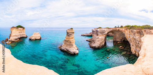 Torre Sant Andrea beach with its soft calcareous rocks and cliffs, sea stacks, small coves and the jagged coast landscape. Crystal clear water shape white stone create natural stacks. Melendugno Italy