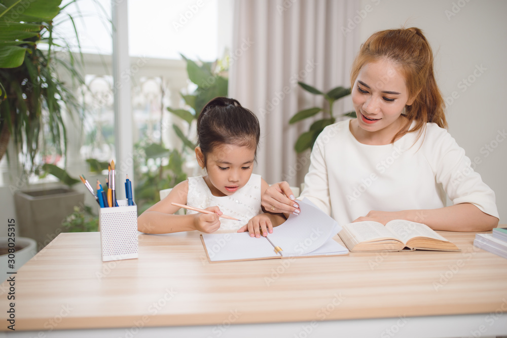 Mother helping her little child with homework Mother helping her little child with homework