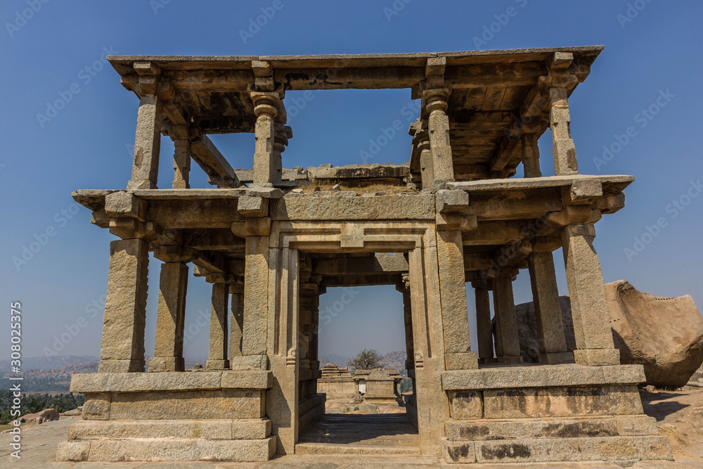 Fototapeta premium Hampi, Karnataka, India - December 10, 2013: A ruined double-storeyed structure made of stone on the Hemakuta hill in the archaeological ruins of the UNESCO heritage site in Hampi.