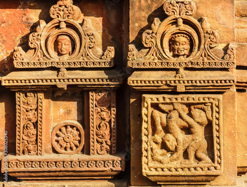 Beautiful, faded carvings on the walls of the ancient 10th century Mukteswara temple in the city of Bhubaneshwar in Orissa, India. photo