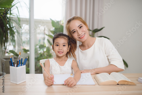 mother and daughter learning to write, mother teaching little girl homework