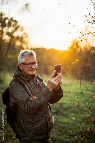 Old man doing selfie in sunset.
