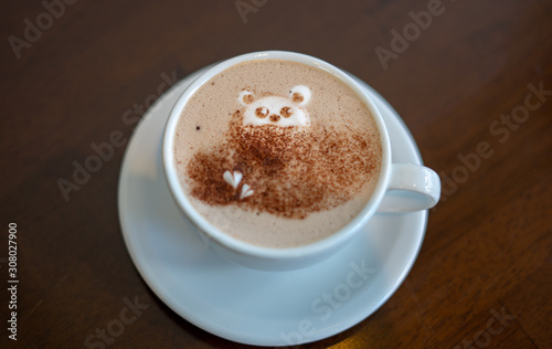 morning coffee. teddy bear latte art made with milk foam.cup of coffee on wooden table