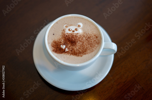 morning coffee. teddy bear latte art made with milk foam.cup of coffee on wooden table