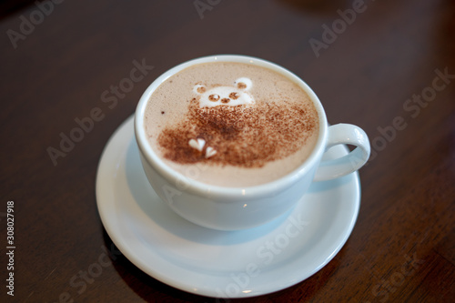 morning coffee. teddy bear latte art made with milk foam.cup of coffee on wooden table
