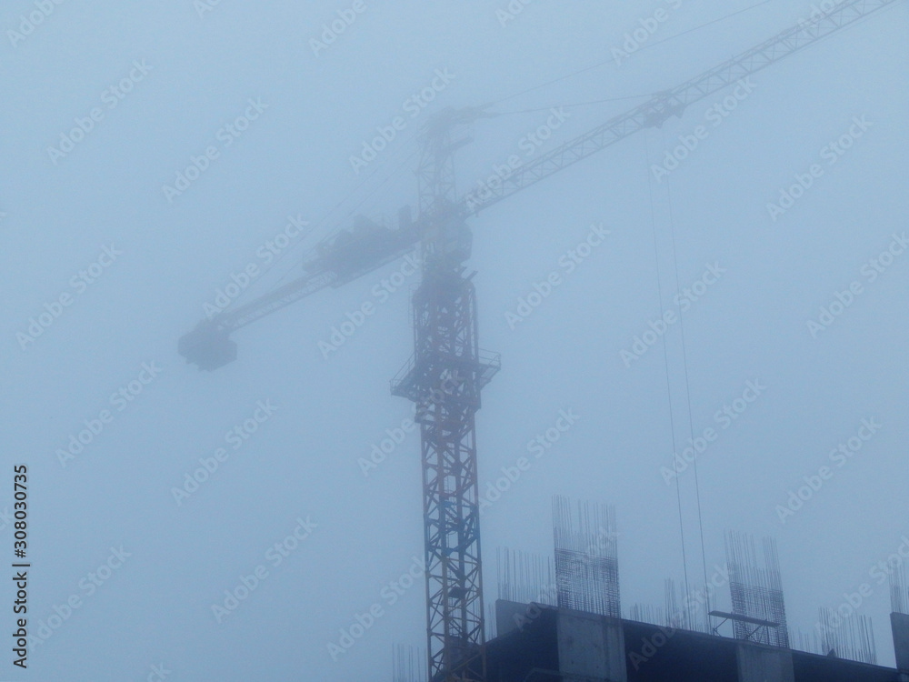 Construction crane in the fog
