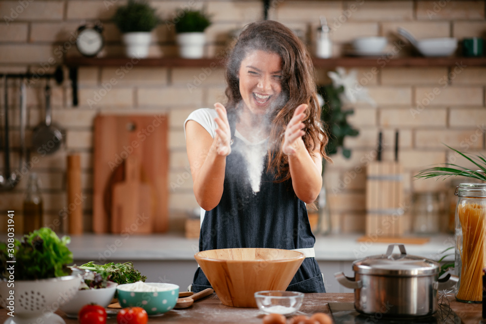 Young woman in kitchen. Beautiful woman playing with flour. Young woman in kitchen. Beautiful woman playing with flour.