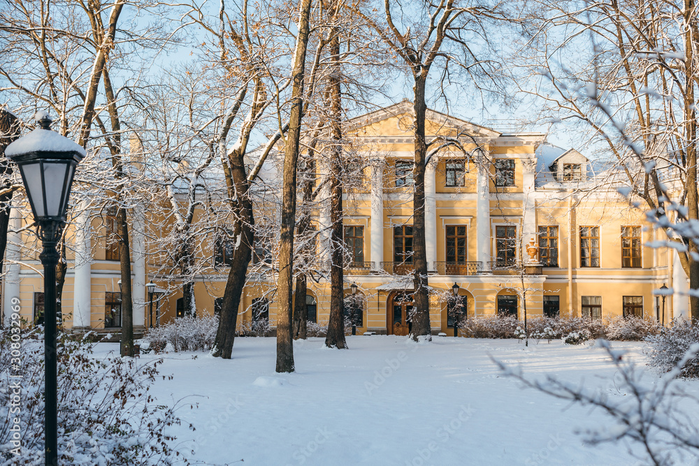 Fabulous snowy urban landscape. Ground and trees cover with fresh snow. On the background yellow palace. Winter season concept. Blue sky and sunlight. Fabulous snowy urban landscape. Ground and trees cover with fresh snow. On the background yellow palace. Winter season concept. Blue sky and sunlight.