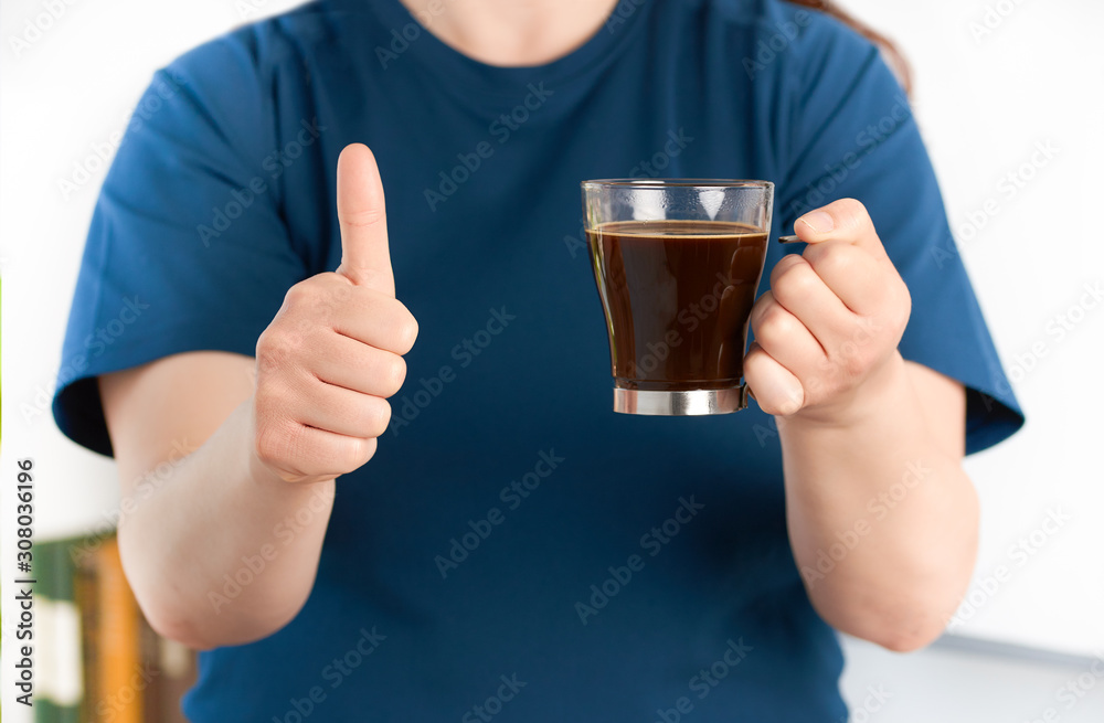 woman hands holding a coffee cup with thumb up woman hands holding a coffee cup with thumb up