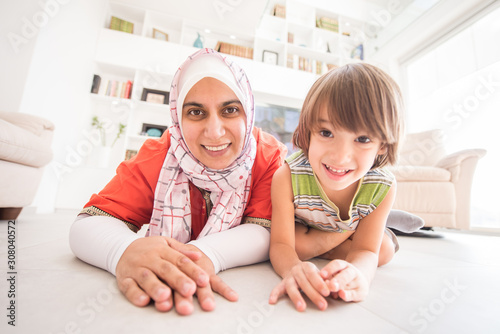 Muslim traditional mother with little cute son at home in living room