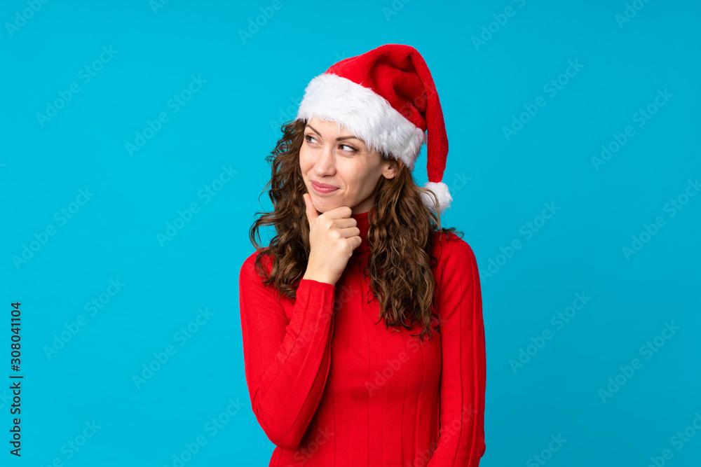 Girl with christmas hat over isolated yellow background thinking an idea Girl with christmas hat over isolated yellow background thinking an idea