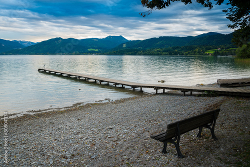 Wooden pier and bench in the beach of Tegernsee lake near Gmund am Tegernsee in Germany photo