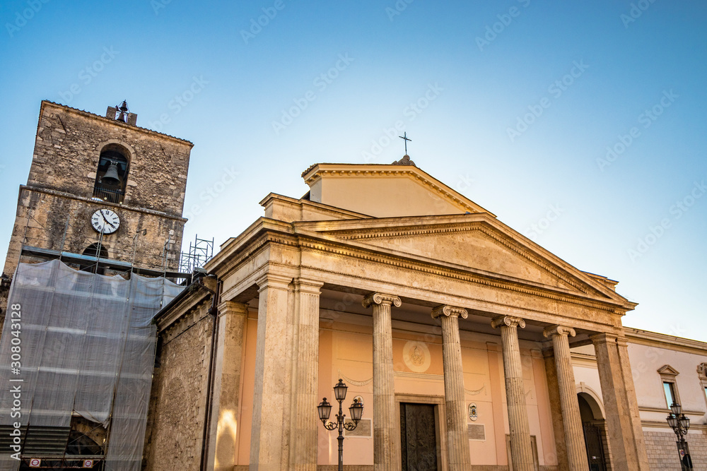 Obraz premium The cathedral of San Pietro Apostolo in Isernia. The facade with a large triangular tympanum in travertine, supported by pillars and columns with Ionic capitals. The portal with bas-reliefs.