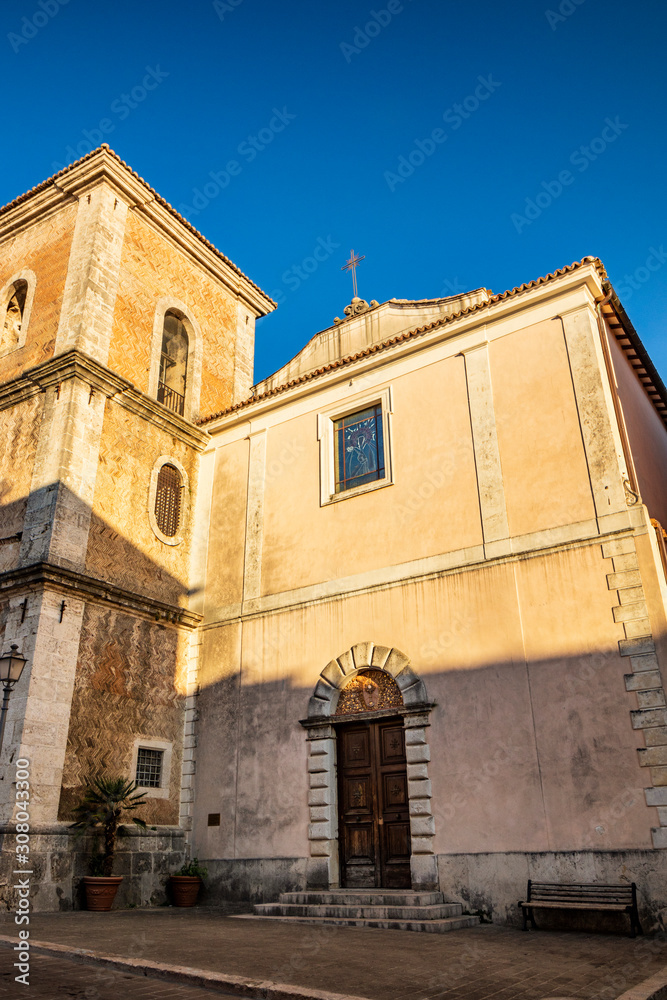 The Church of Santa Chiara, built in 1275, in the historic center of Isernia, Molise, Italy. The bell tower, the crucifix and the wooden portal with a round arch.