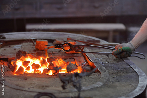 Hot coals in a furnace for heating metal for manual forging in a blacksmith workshop