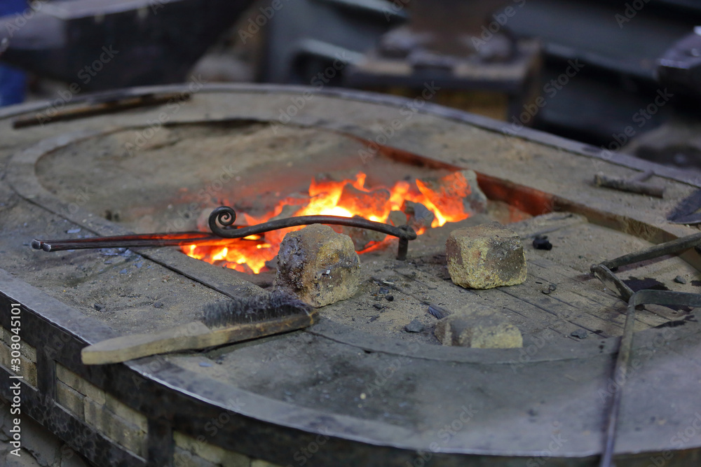 Hot coals in a furnace for heating metal for manual forging in a blacksmith workshop